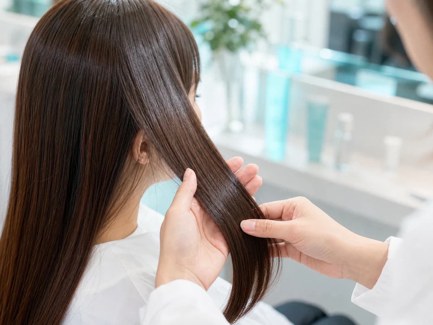 美容師がお客様の髪の質感を確認しているサロンのクローズアップ